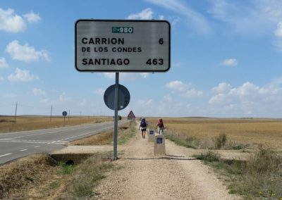 A photo of the senda and a distance sign to Santiago